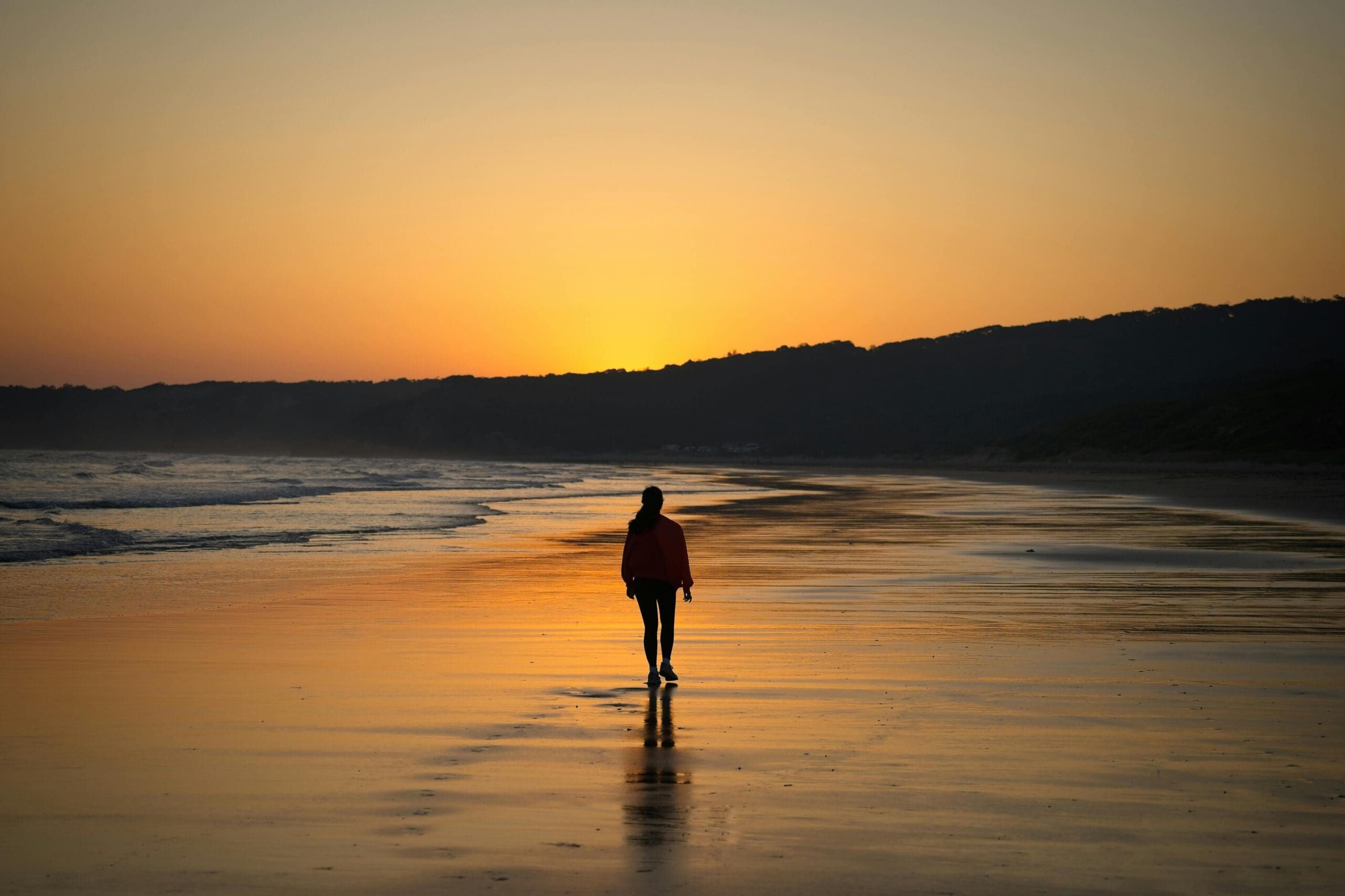woman walking on the beach in the sunset